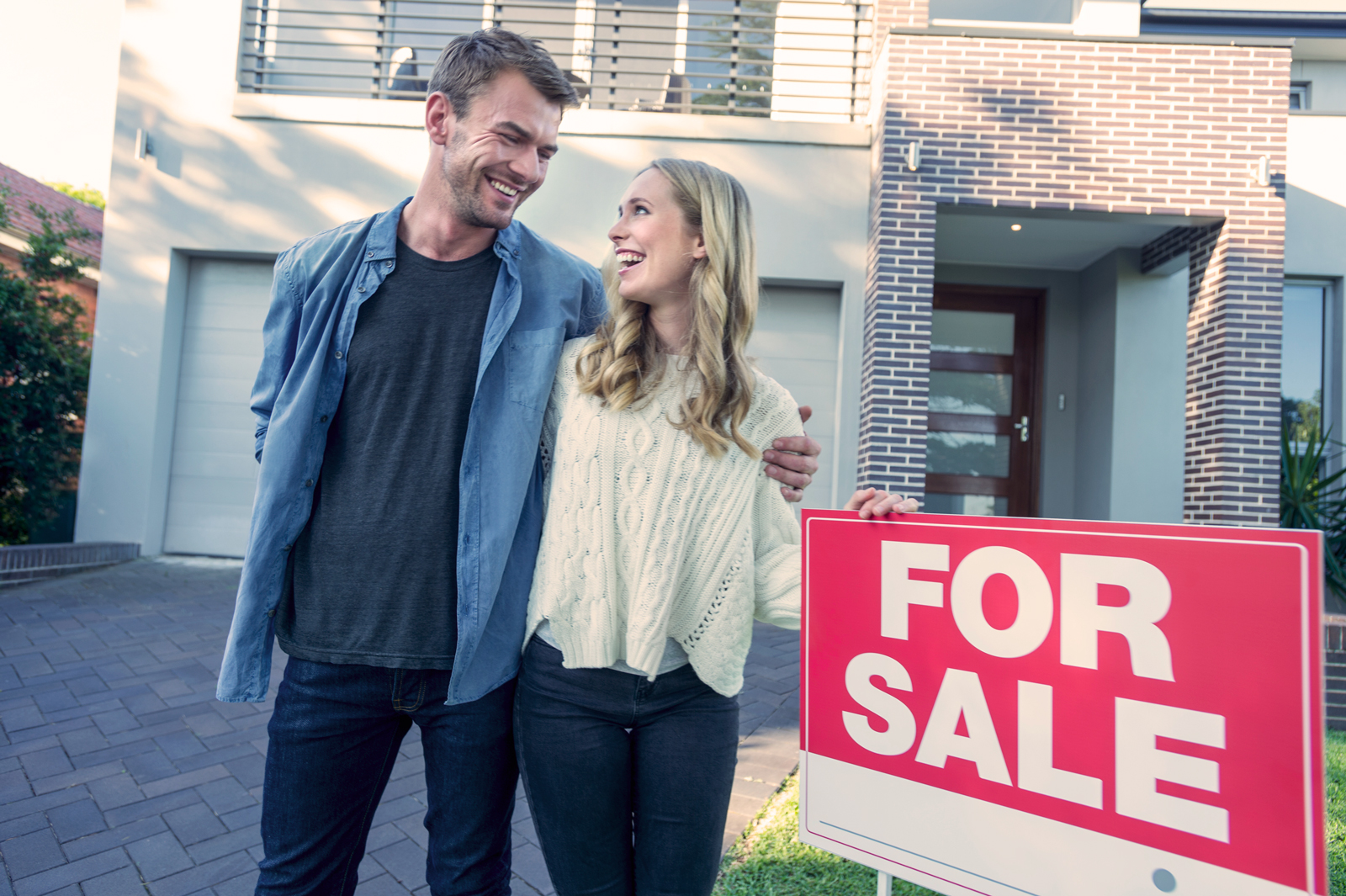 Couple standing in front home for sale