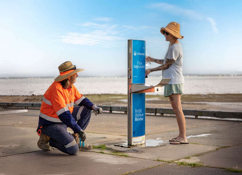 Customer talking to Unitywater team member while filling up water bottle at Unitywater fill station