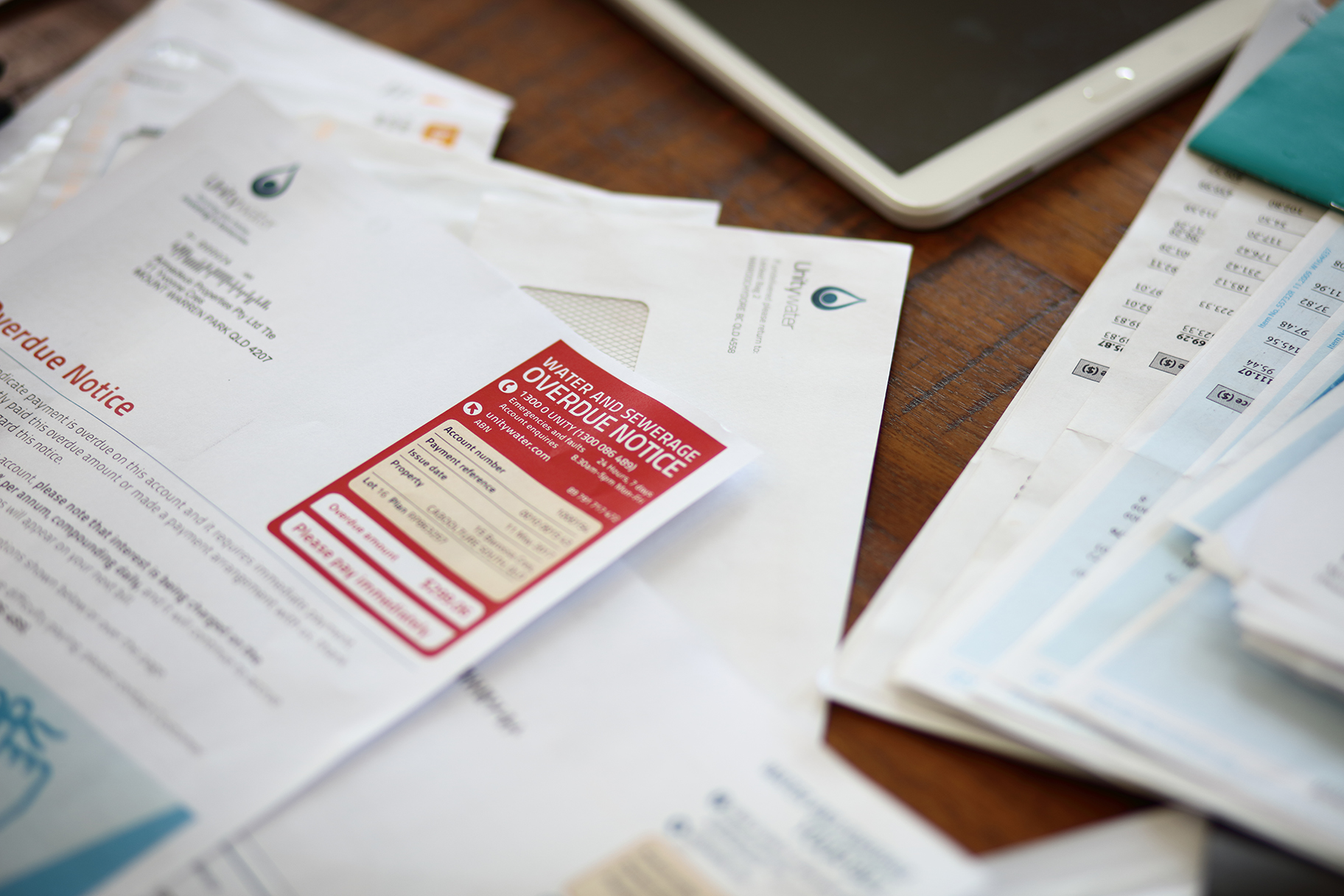 Unitywater bill overdue notice on desk with pile of papers