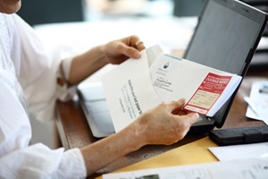 Woman pulling Unitywater bill overdue notice out of envelope