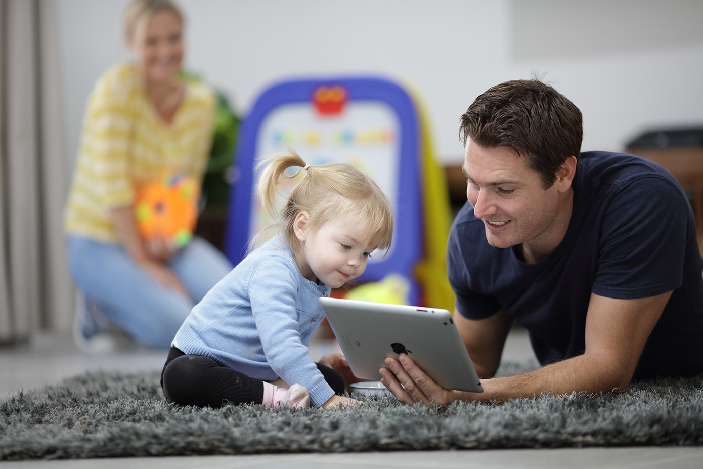 Man and young child in residential home looking at iPad