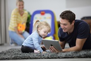 Man and young child in residential home looking at iPad