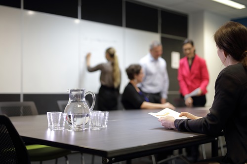 Business people in meeting room with jug of water 