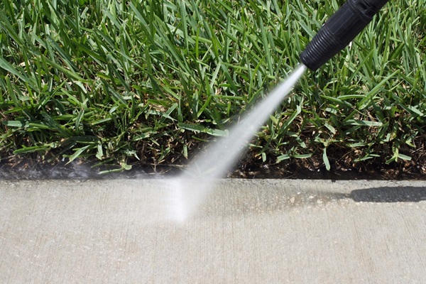 High pressure water hose cleaning cement path
