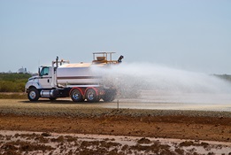 water truck spaying water on road at construction site