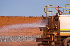 water truck spaying water on road at construction site