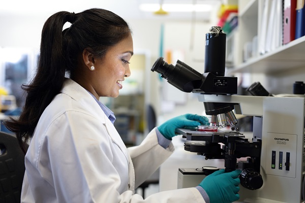 Female lab technician looking in microscope