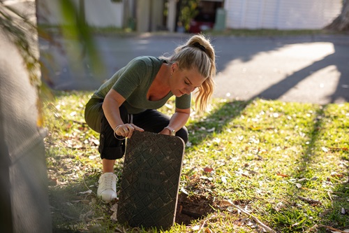 Woman checking water meter box in garden