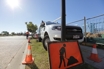 Hydrant and valve replacement truck on side of road with safety signage