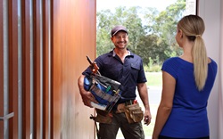 Plumber and woman at front door of residential house