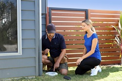 Plumber and woman looking into ORG at residential house