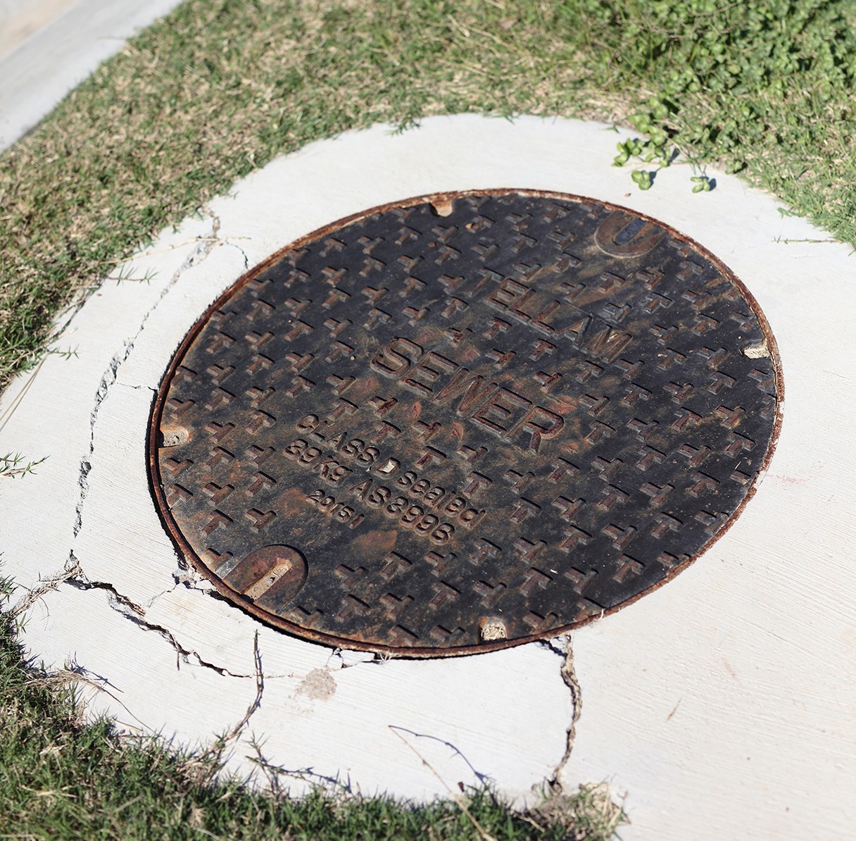 Cracked sewer manhole on residential street