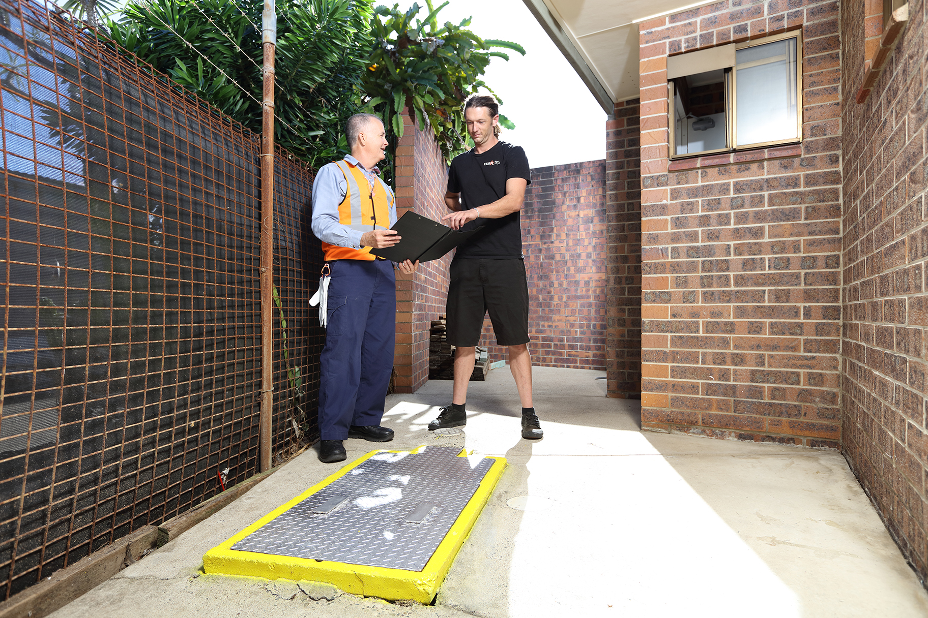 Trade Waste Officer and business owner looking at grease arrestor