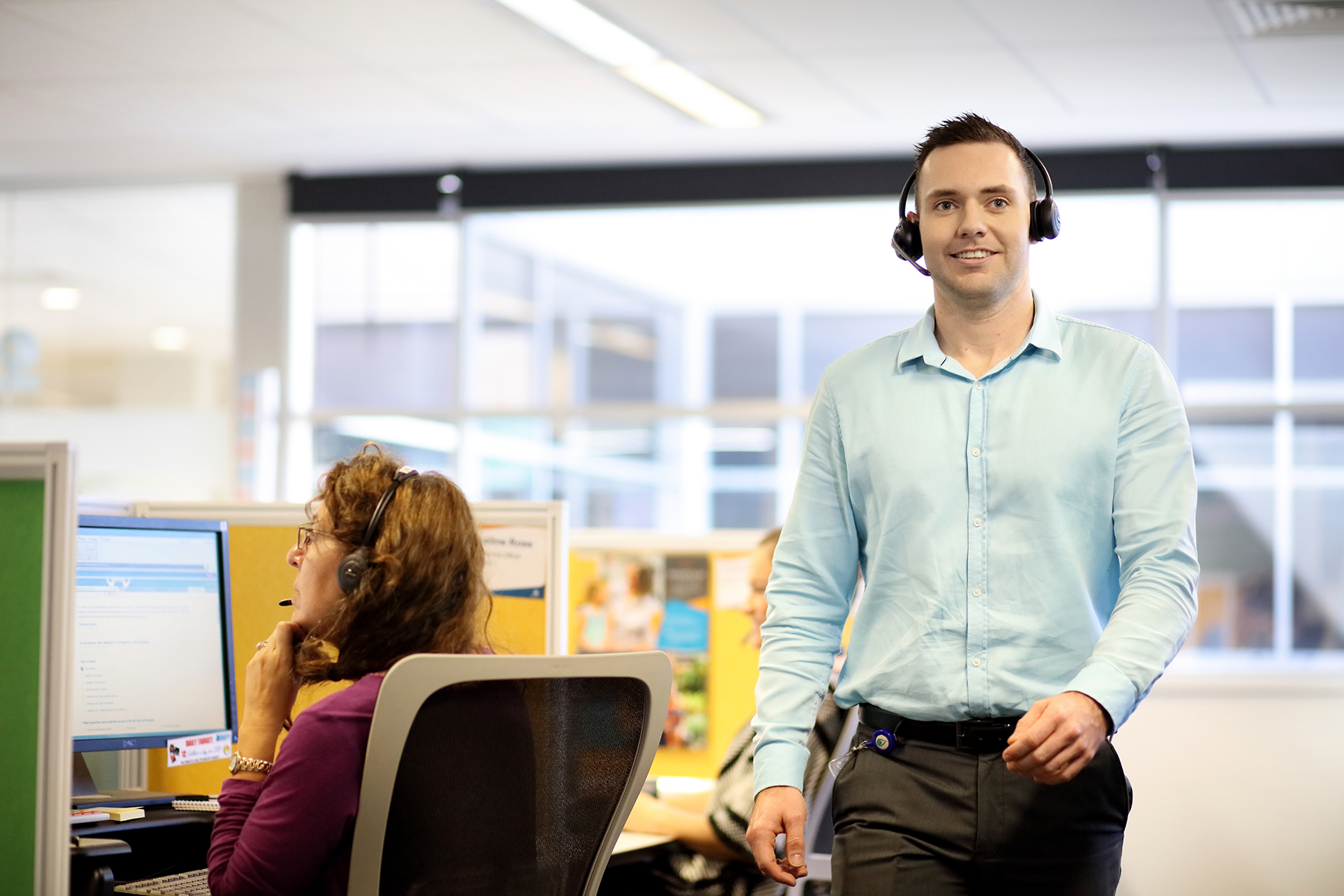 Man wearing headphones working in contact call centre
