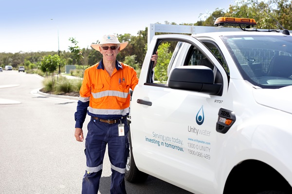 Male Field Crew staff member standing next to Unitywater utility vehicle