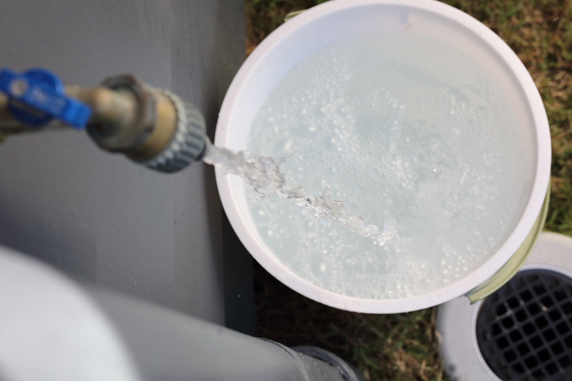Clear water running from tap into bucket to clear pipes after water outage