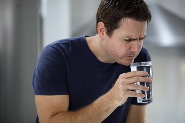Male customer smelling glass of water