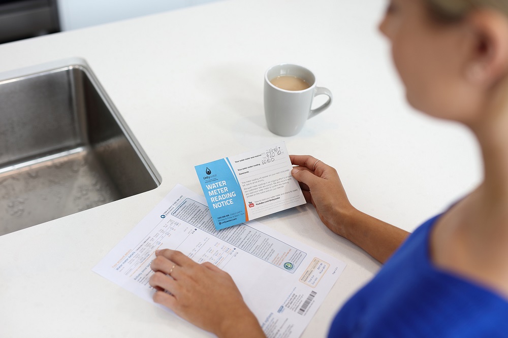 Woman comparing meter reading notice with bill