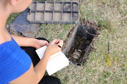 Woman recording water meter reading