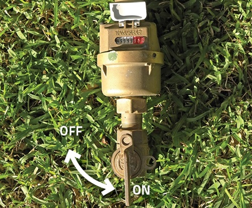 Water meter in grass showing how to turn the stop tap off