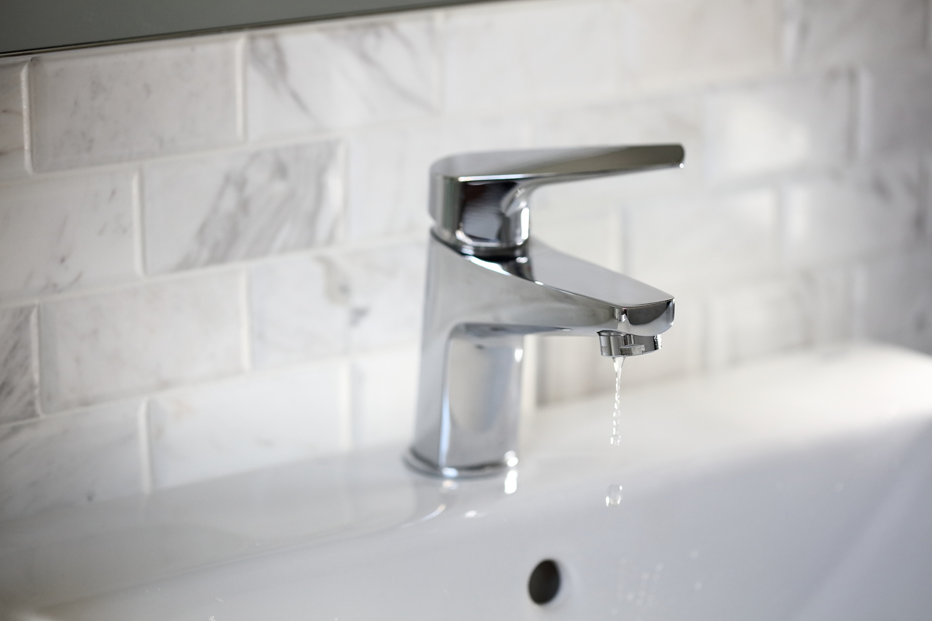 Tap dripping water in residential bathroom sink