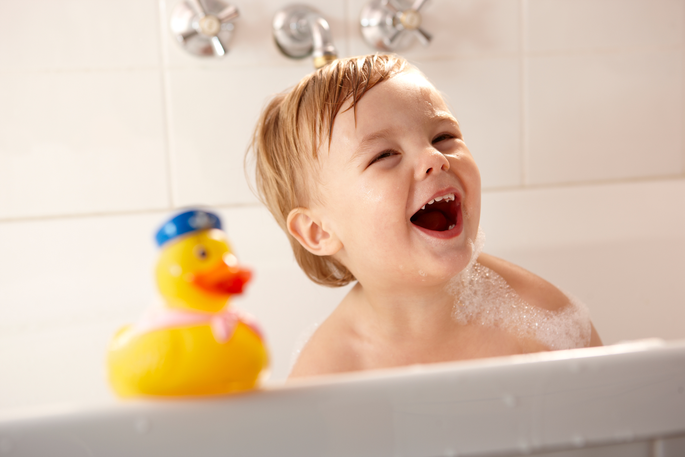 Toddler in the bath with rubber duck