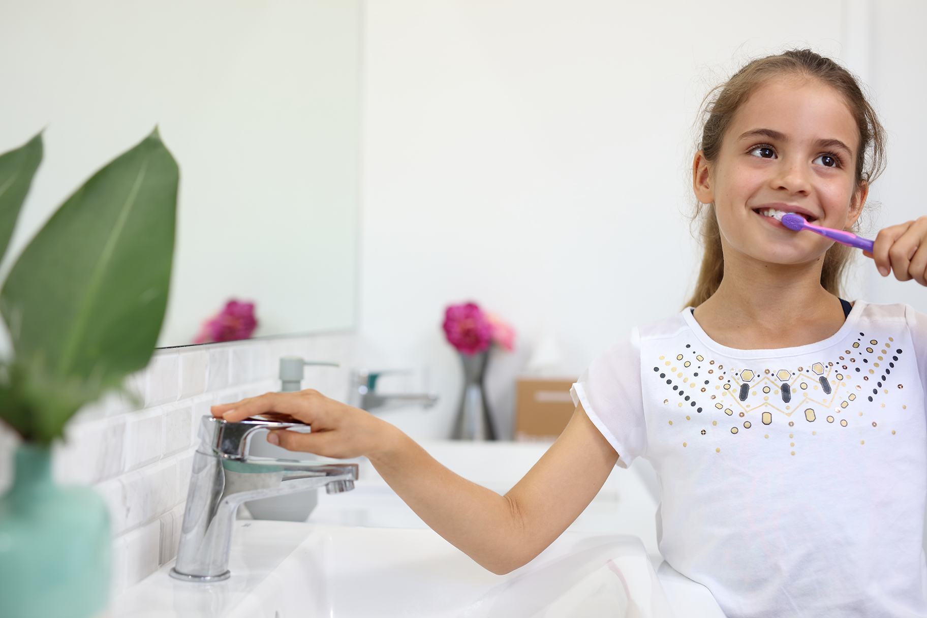Young girl brushing teeth in bathroom