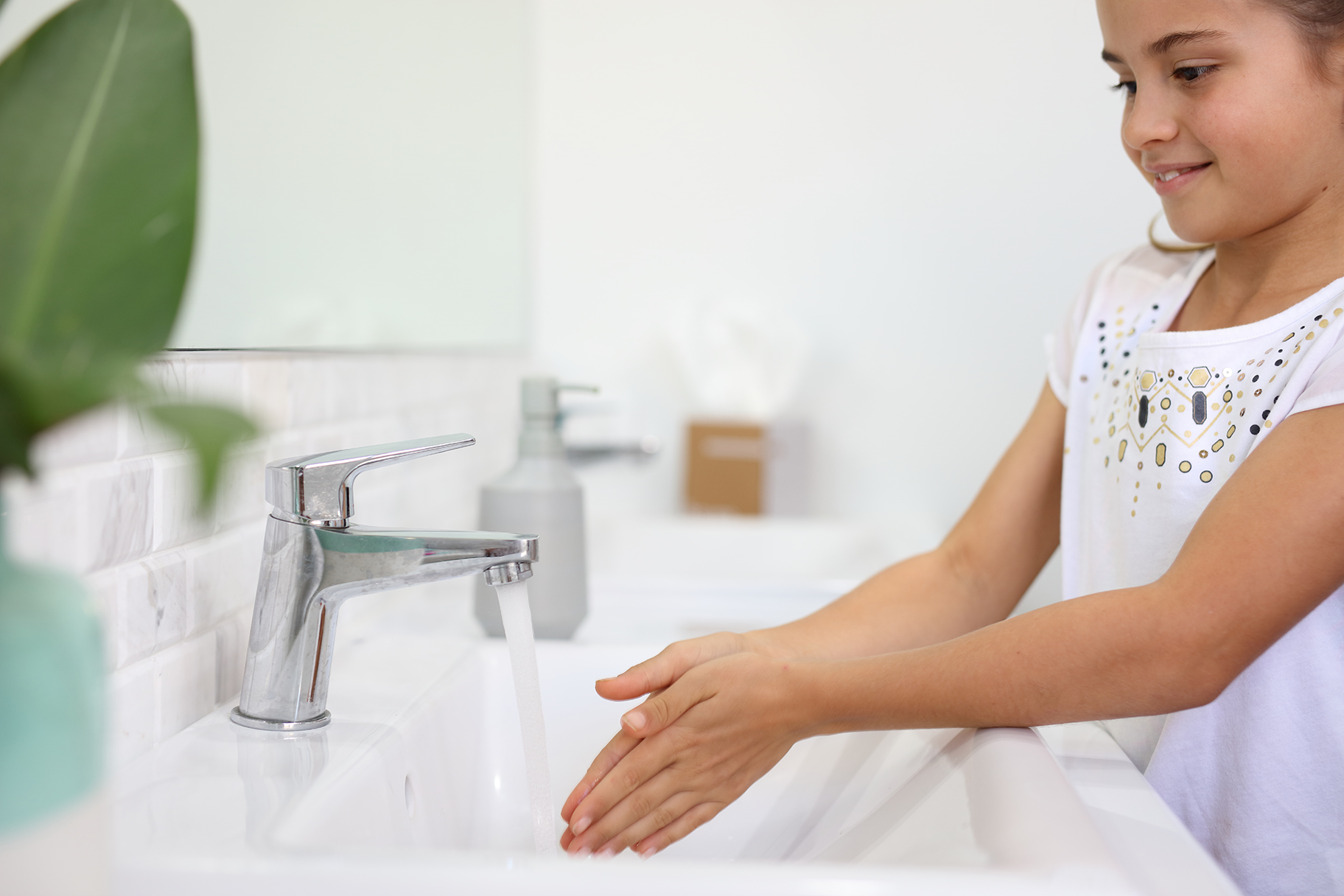 Young girl washing hands at bathroom sink