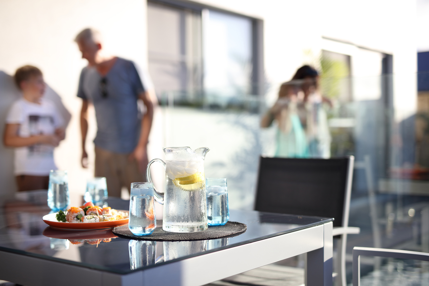 Sushi and water refreshment on table in residential backyard