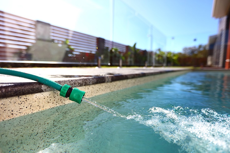 Hose filling residential pool with water