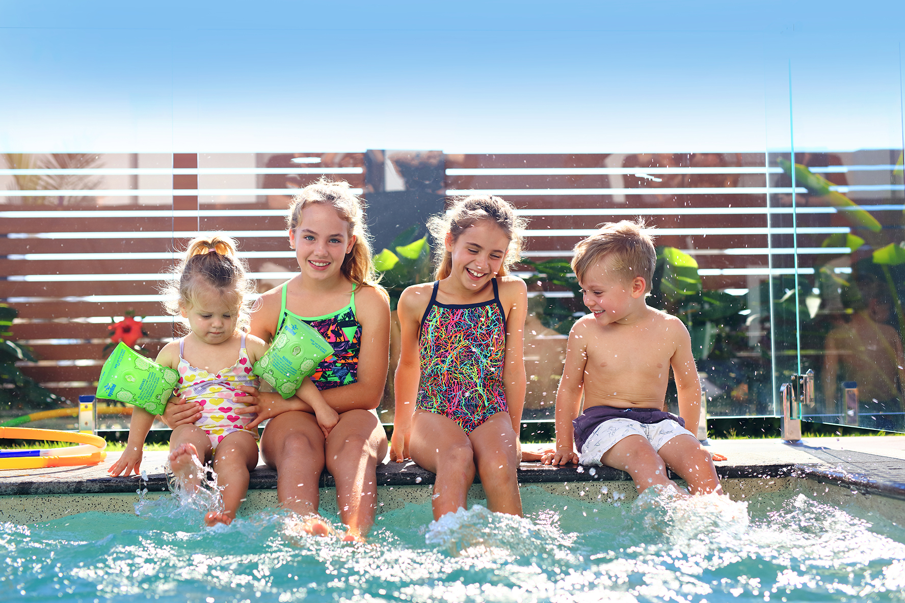 Kids sitting by residential pool